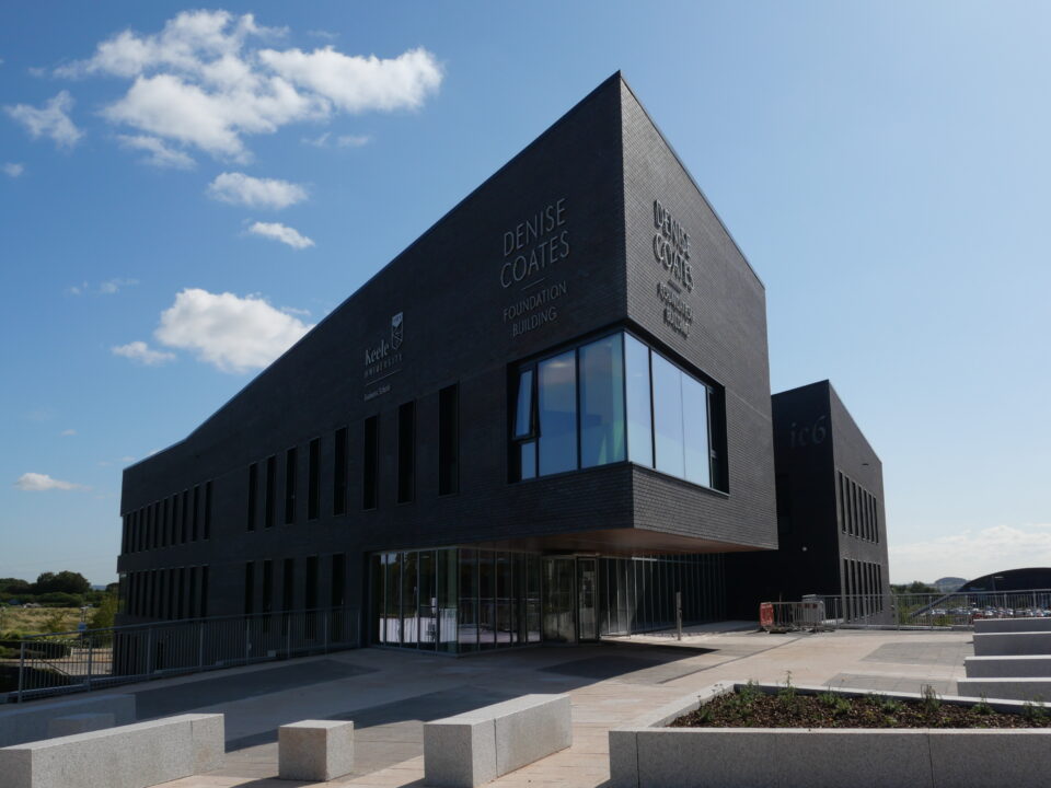 Keele University’s Smart Innovation Hub, a modern, angular building with dark brickwork and large windows.